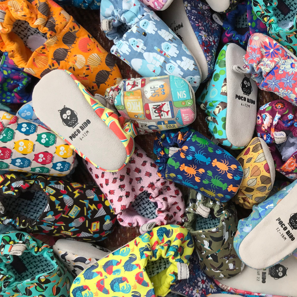 Colorful mini shoes with various patterns and designs in a pile.