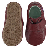 A pair of childrens adjustable strap shoes, one viewed from the top, one is a view of the sole. They are in wine red leather with a large adjustable strap over the top of the foot. They have a  pale blue leather lining and insole. The sole is a natural gum colour.