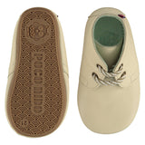 A pair of childrens lace up desert boots, one viewed from the top, one is a view of the sole. They are in chalk colour leather with striped laces. They have a  pale blue leather lining and insole. The sole is a natural gum colour.