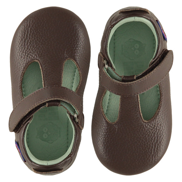 A pair of childrens T bar shoes, viewed from the top. They are facing in opposite directions. They are in dark brown leather. They have a pale blue leather lining and insole and an adjustable strap. The sole is a natural gum colour.